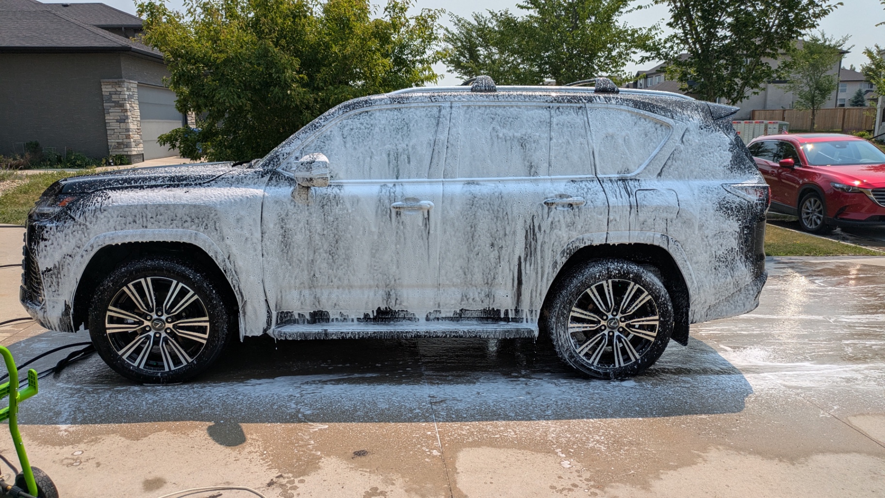 Snow-foam pre-soak lifting grime off every panel